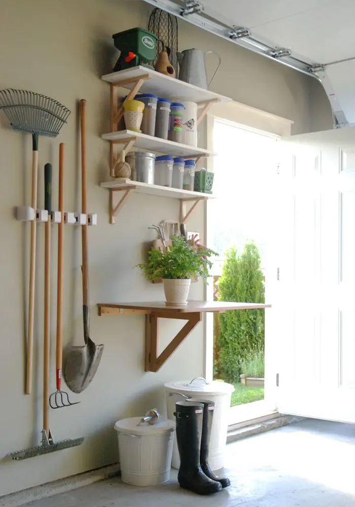 From Mini Manor Blog. I love this organizational station for yard and garden supplies. The table (for potting) folds down so the car can come in. The smaller tools are in the bag begin the fern and the larger tools are hanging. Soil in bigger trash can.: 