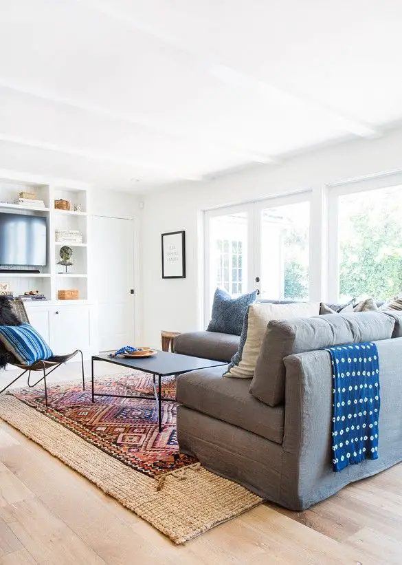 Cozy white living space with sectional and blue throw: 