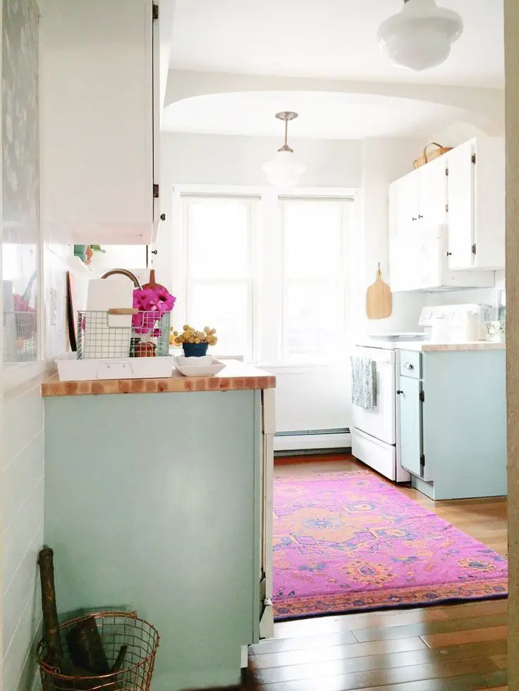 Pink Persian rug and light blue cabinets in kitchen: 