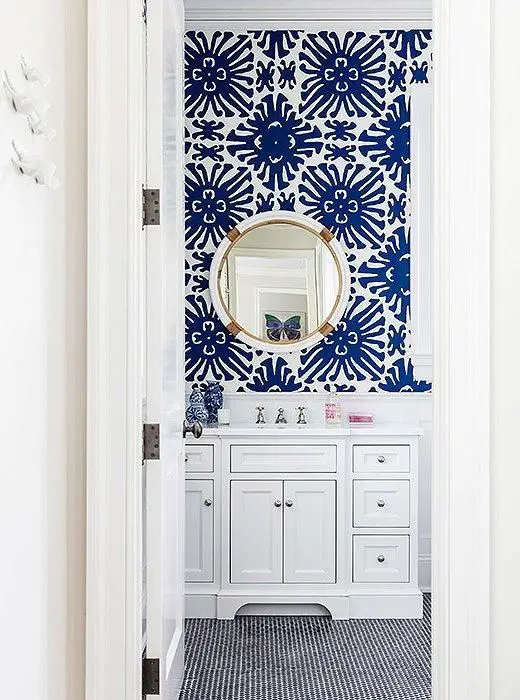 Obsessed with the bold cobalt blue and white geometric sunburst patterned wallpaper and shiny brass and chrome accents in this adorable bathroom.  Read more on our Style Guide, "Inside Sue De Chiara's Gorgeous Connecticut Home That's  Both Totally Traditional and Full-On Fun!": 