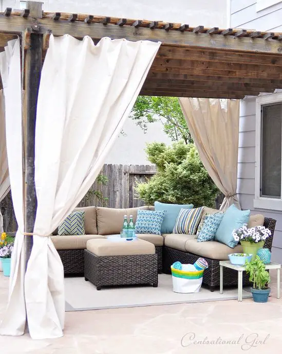 Easy outdoor curtain diy tutorial made from Lowes' canvas drop cloths and grommets! We could also add corner seating like this, where the hot tub will someday(hopefully) go. then move it out to the extra patio pad when that happens...