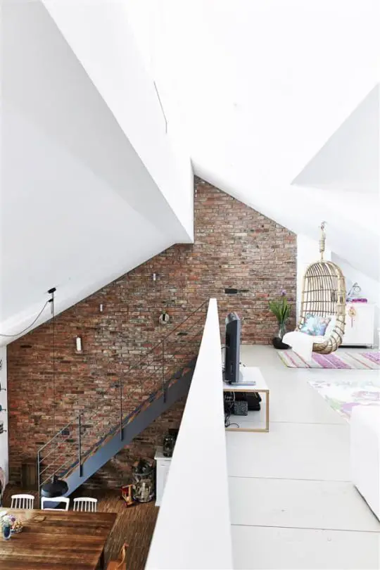 Frankfort, Germany | Built from a recycled barn, one entire side of the house is built from the old barn brick, each of which have been washed with a brush. Beams have been recycled as structural support for the mezzanine where there's a family room (with a lovely wicker swing!) and study. Love the stairs and the multi-angled ceiling as well.: 