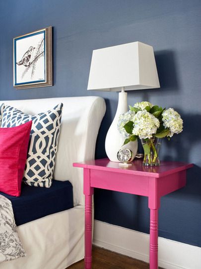 Awesome idea! Get a cheap nightstand. Paint it, and cut it in half. Screw each half into each side of the bed, so you and your partner both have your own little nightstand!