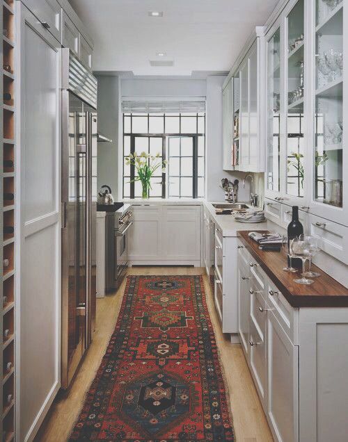 kitchen - wood counters countertops, white cabinets with glass doors over visible shelves, vintage oriental rug runner: 