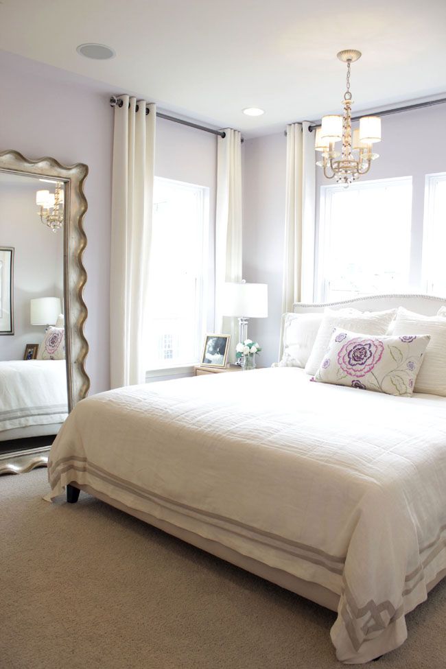 By using a large wall mirror, hanging the drapery rods higher above the window with light window treatments, this space seems a lot larger. I love this #bedroomdecor: 