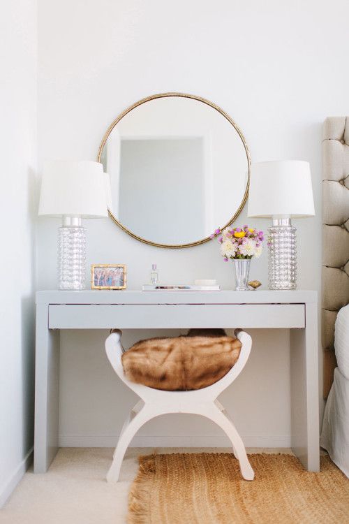 Sneak Peek: A Chicago Apartment with a Sartorial Approach. "There’s something about the routine of sitting down and taking time to get ready that seems so glamorous. I had my dad spray paint a plain white Ikea Malm dressing table a high gloss gray then paired it with this fabulous brass mirror from CB2 – such an unexpected find!" #sneakpeek
