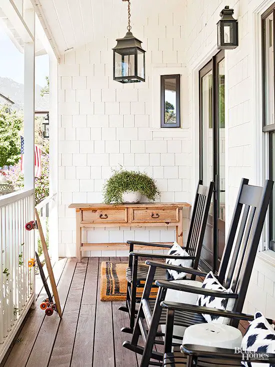 This picturesque porch was made for glasses of iced tea and shooting the breeze on summer evenings. Black rockers echo the home's dark trim and connote throwback comfort in a slightly more modern silhouette, amplified by ikat pillows in black and white.: 