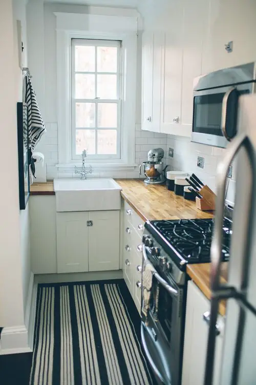 Navy blue cupboards, white tiles, and gold details in this clean Brooklyn kitchen // Photo c/o onefinestay