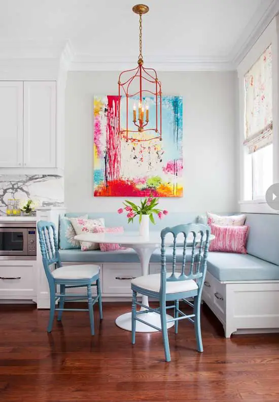 Lovely colorful breakfast/ dining in the kitchen! Pastel blue banquette seating, Saarinen inspired table and blue painted chairs with a pop of brights in the art and light.: 