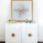 white-cabinet-gold-flower-knobs-pastel-colored-abstract-art