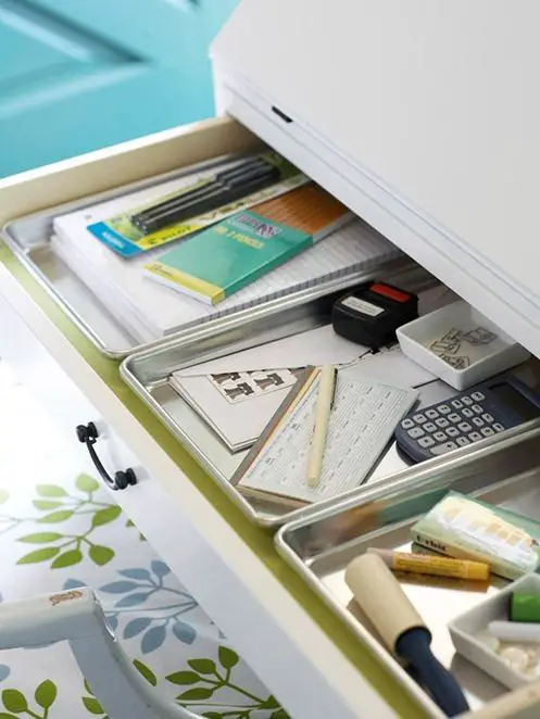 Culinary Cleverness.  Small baking pans are just shallow enough to slide inside a desk drawer, and so perfect for avoiding clutter by keeping smaller office necessities from blending together in an useless pile.