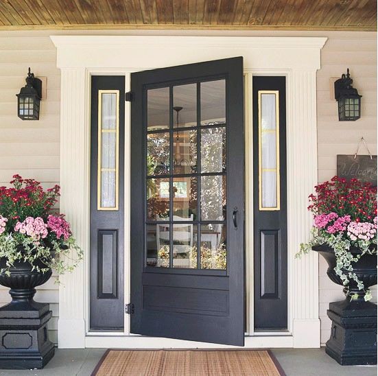love the urns with flowers spilling over.  great front door.  like its a lighter shade of black and that its not high gloss