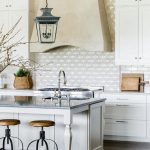 tan-kitchen-range-hood-with-white-cabinets