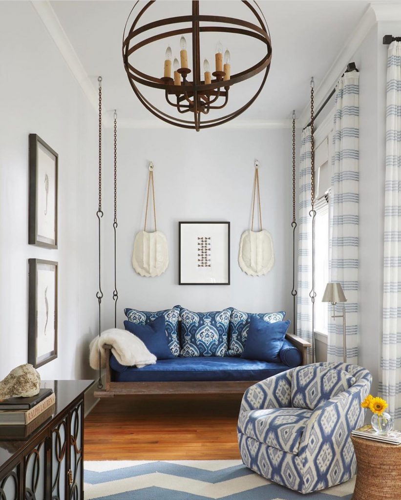 Living room with chair, couch with blue pillows and round chandelier
