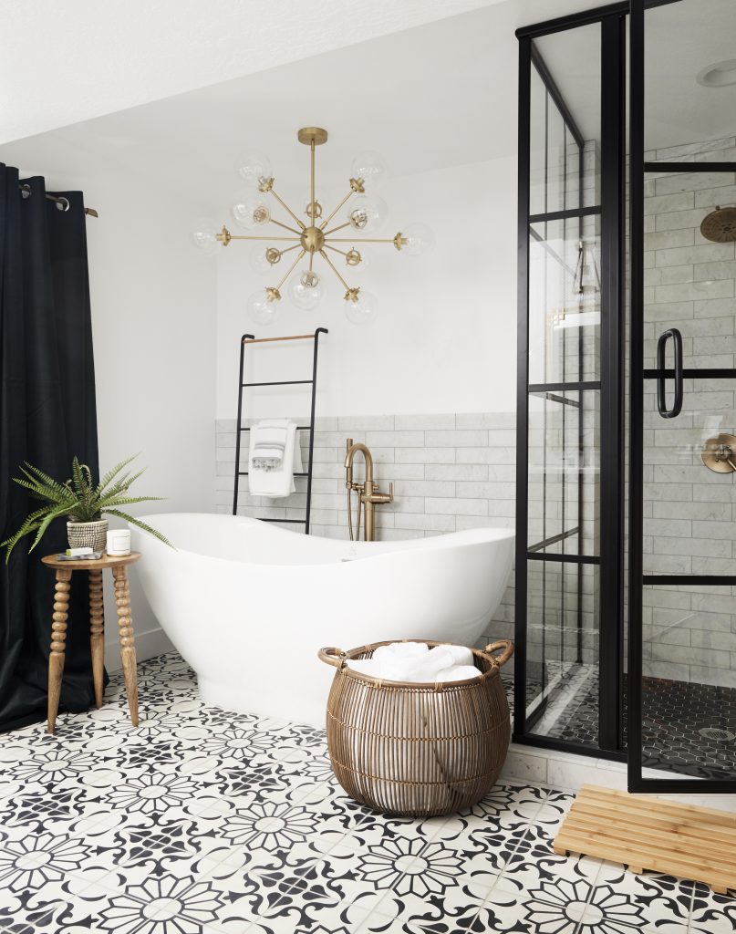 Bathtub with golden chandelier and black curtains