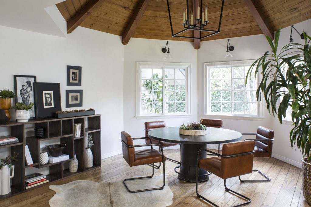 Dining room with black table, leather coated chairs, and black shelfs with books and pictures