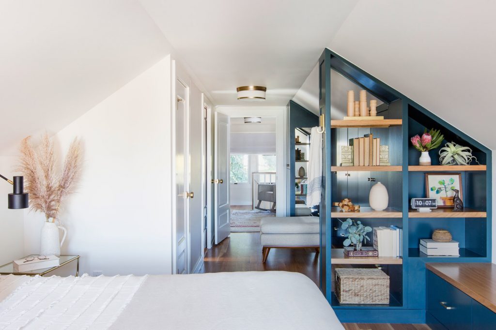 View from bedroom with bed and book shelf into hall