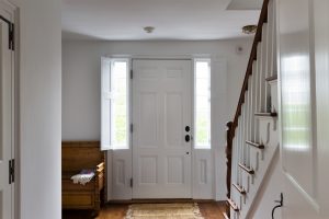 Hall looking to white entrance door