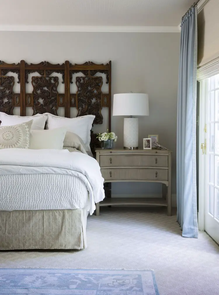 Bedroom with nightstand with lamp on top and curtains on the window