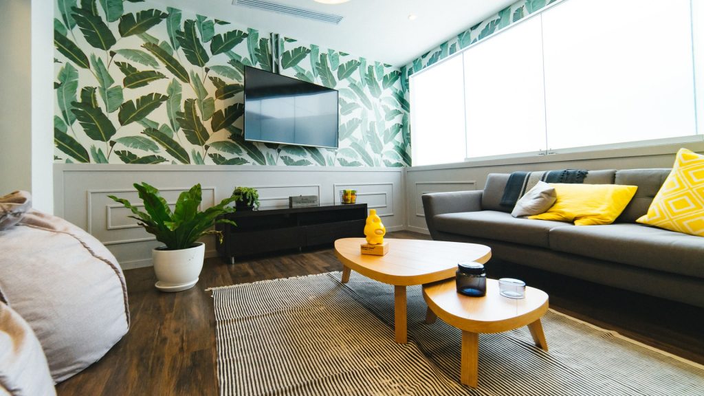 Living room with coffee table, couch and TV on the wall