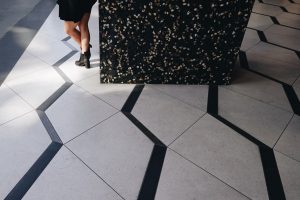 Tile flooring and woman standing next to pillar