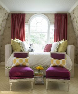 Living room with white sofa, red chairs an window curtains