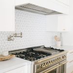 White designed kitchen with oven and cooking hood