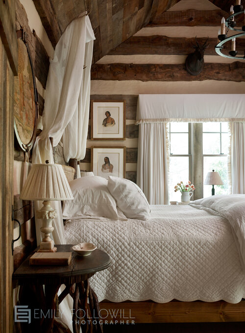 Bedroom with nightstand, double bed and pictures beside the window