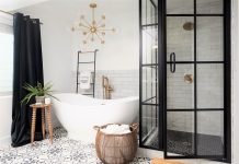 Bathtub and black shower with glass, black curtain and woven basket with laundry