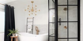 Bathtub and black shower with glass, black curtain and woven basket with laundry