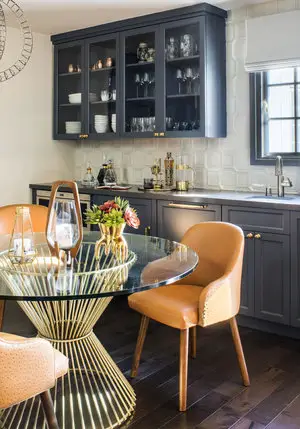 Kitchen with gray kitchen elements, round table and orange chairs