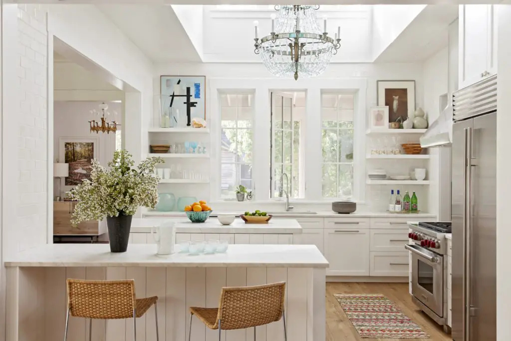 White designed kitchen with table, chairs and kitchen elements