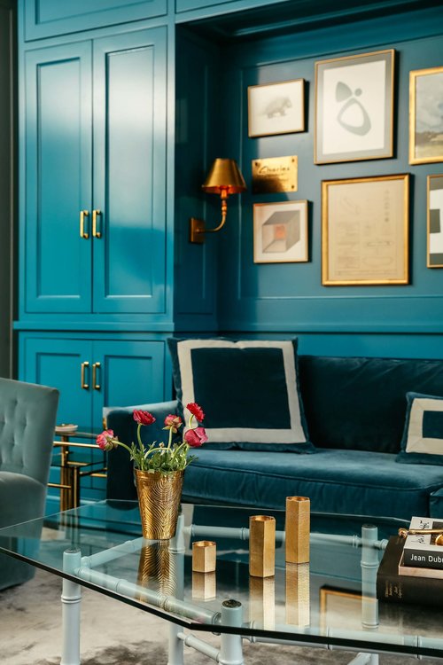 Blue room with blue closed and sofa and coffee table with tulips in vase