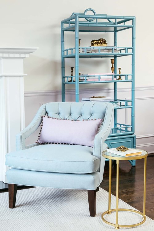 Light blue armchair, little round table and blue shelfs beside the firework