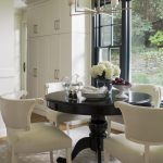 Black dining table with flowers and white chairs