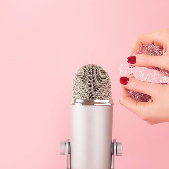 Microphone and woman's hands holing paper to make a sound