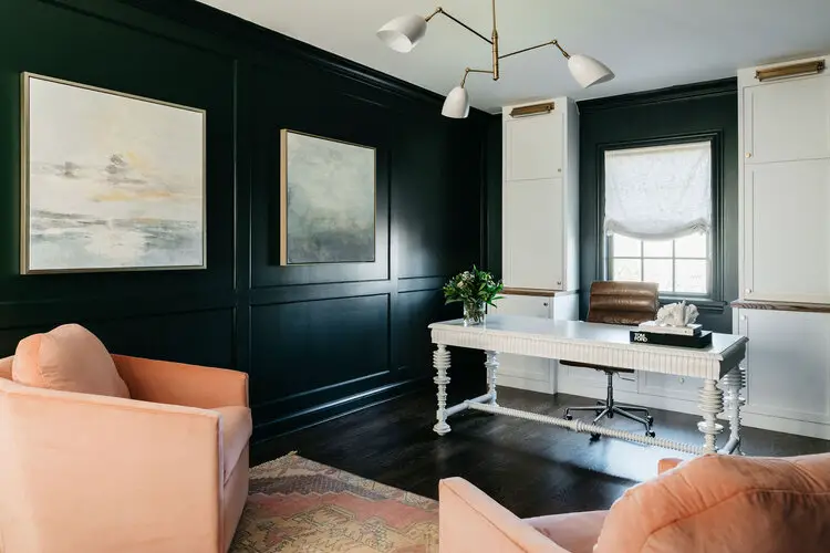 Home office with black wall and white table