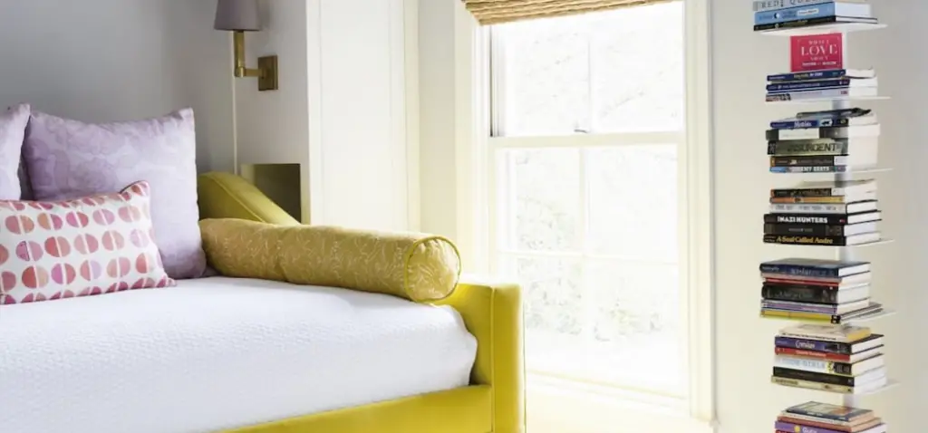 Bedroom with single bed used as sofa beside the window and book shelf