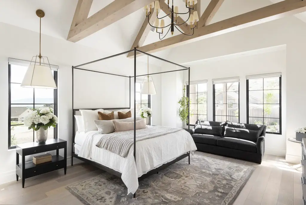 Bedroom with large framed bed, carped and wooden beams