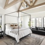 Bedroom with large framed bed, carped and wooden beams