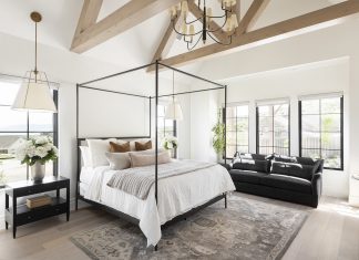 Bedroom with large framed bed, carped and wooden beams