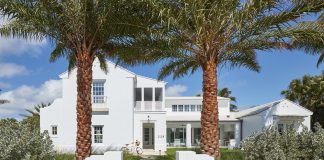 White house with front yard and palm trees