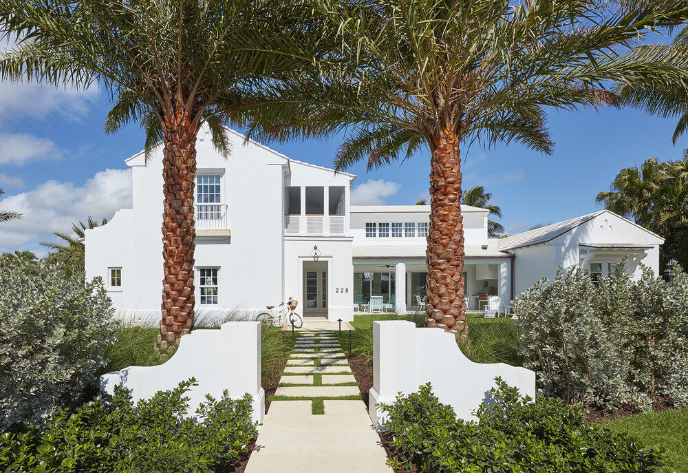 White house with front yard and palm trees