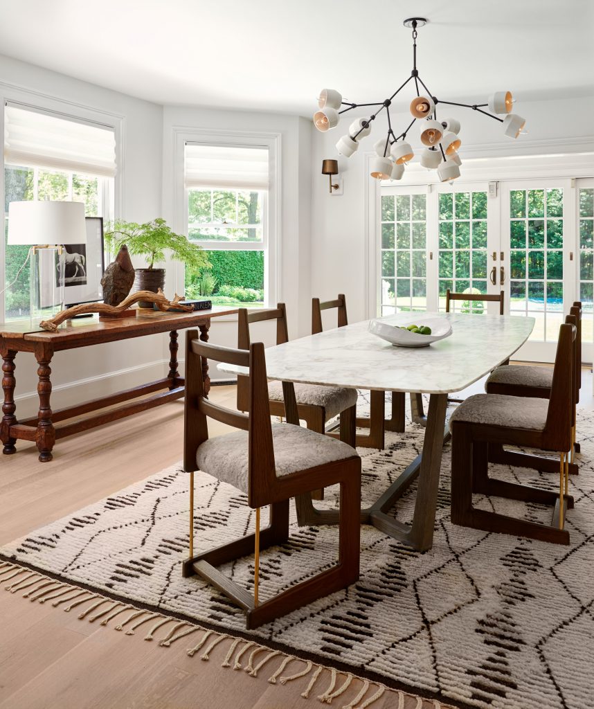 Dining table with celling above and carpet under the table surrounded with chairs