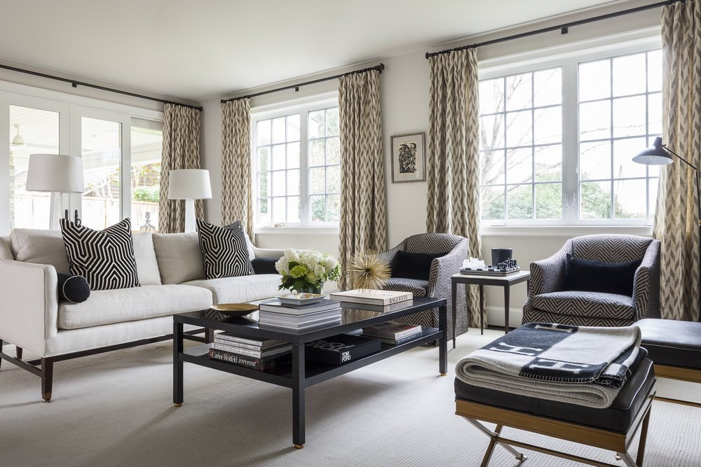 Living room with table, chairs, sofa and big windows in the background