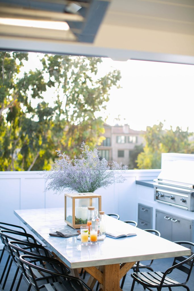 Outdoor dining space with BBQ, dining table and chairs on the balcony