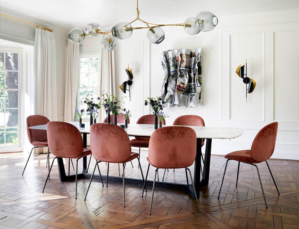 Dining table with chairs around it and vases with flowers on the table