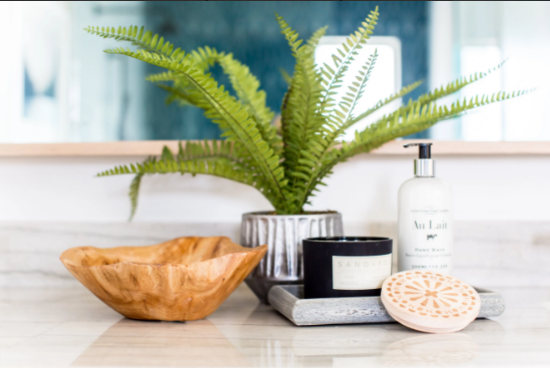 Plant in a vase, soaps and creams in the bathroom