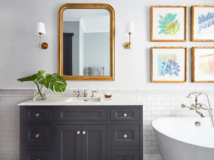 Bathroom with bath tub and bathroom cabinet and sink with big mirror with golden frame