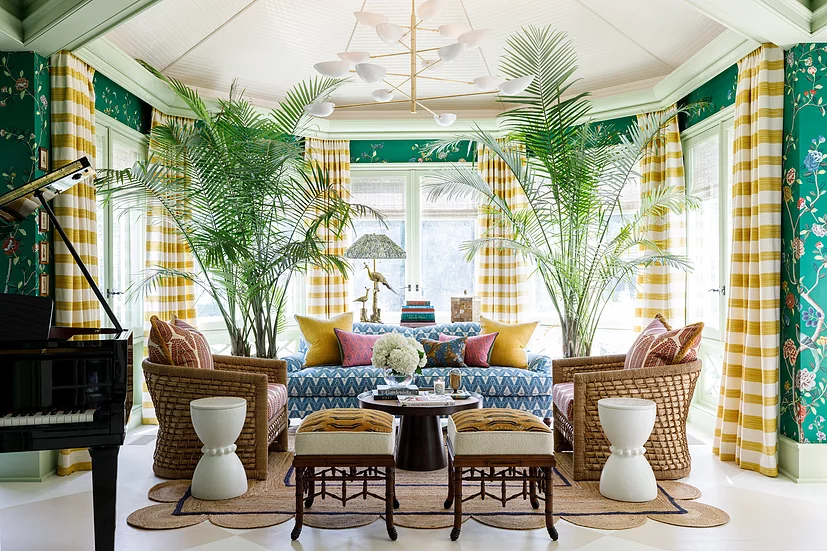 Colorful living room with sofa, armchairs, palm trees in the pots, striped curtains and wide windows, with a black grand piano in the corner